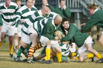 Group of people tackling a rugby player