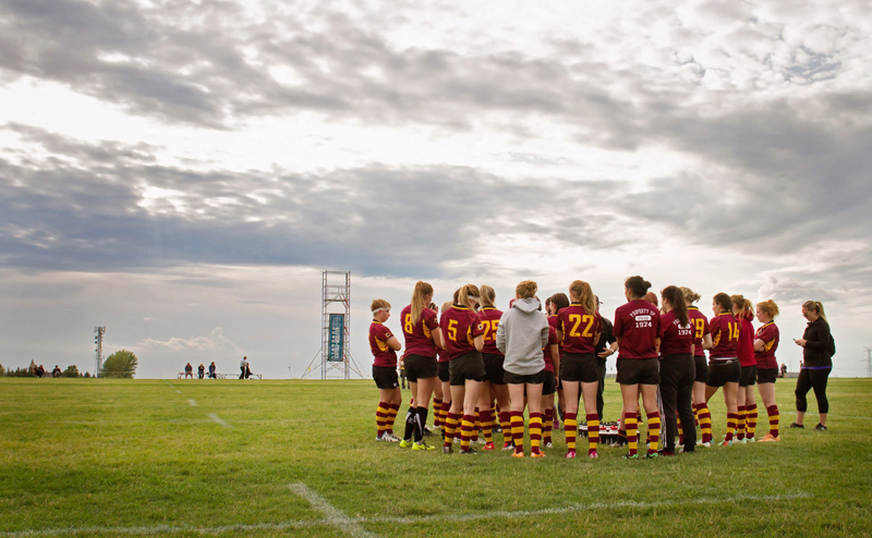 Group of soccer players huddled on a sports field